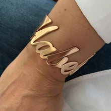 Load image into Gallery viewer, A gold-plated stainless steel bangle cuff bracelet with the name 'Mabel' engraved on the wrist.