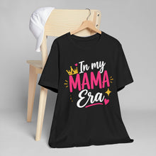 Load image into Gallery viewer, Black t-shirt with 'In my MAMA Era' text on a hanger against a gray background