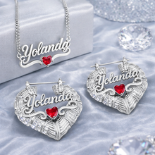 Load image into Gallery viewer, Silver heart jewelry set with 'Yolanda' and red heart details on a light blue fabric background.
