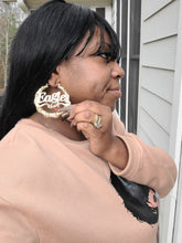 Load image into Gallery viewer, Woman wearing a large hoop earring with 'EAGLES engraved on it, sitting on steps.