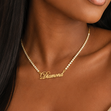 Load image into Gallery viewer, Woman wearing a gold tennis necklace with in stones 'Diamond' pendant in an elegant indoor setting.