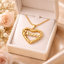 Load image into Gallery viewer, Gold heart-shaped necklace with 'Deonna' engraving in a jewelry box with flowers in the background