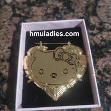 Load image into Gallery viewer, Gold Hello Kitty heart earrings in a box with 'hmuladies.com' branding.