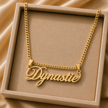 Load image into Gallery viewer, Gold necklace with the name "Dynastie" in a beige jewelry box.