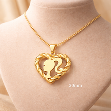 Load image into Gallery viewer, Gold necklace with a heart-shaped pendant featuring a silhouette on a mannequin bust.