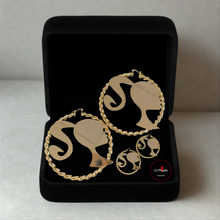 Load image into Gallery viewer, Gold Barbie-shaped earrings in a black box on a light gray background
