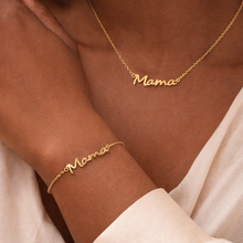 Load image into Gallery viewer, Gold 'Mama' necklace and bracelet on a wrist against a neutral background