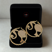 Load image into Gallery viewer, Barbie Silhouette Gold hoop earrings in a black jewelry box on a light gray background