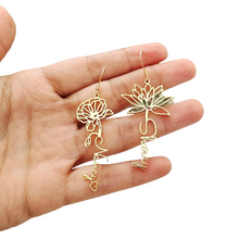 Load image into Gallery viewer, A hand holding a pair of gold-plated stainless steel flower earrings with personalized nameplate.
