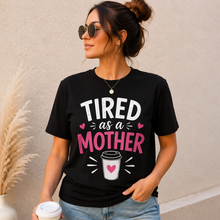 Load image into Gallery viewer, Woman wearing a black t-shirt with 'TIRED as a MOTHER' text and holding a coffee cup.
