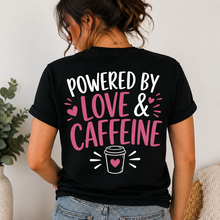 Load image into Gallery viewer, Person wearing a black t-shirt with 'Powered by Love &amp; Caffeine' text and coffee cup graphic on back of shirt.
