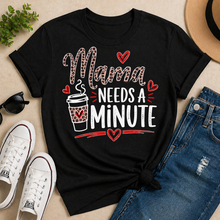Load image into Gallery viewer, Black t-shirt with 'Mama Needs a Minute' design on a beige surface with shoes, jeans, and a hat.
