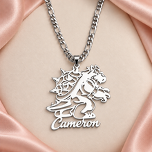 Load image into Gallery viewer, Silver dinosaur cutout name pendant reading Cameron on a Figaro chain with ivory and blush background
