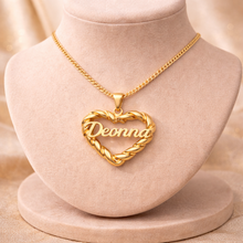 Load image into Gallery viewer, Gold heart-shaped necklace with 'Deonna' pendant on a beige stand
