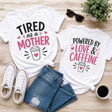 Load image into Gallery viewer, Two white t-shirts with humorous sayings on front and back of shirt on a wooden surface with shoes and a plant.
