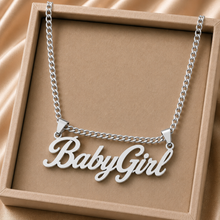 Load image into Gallery viewer, A silver necklace with the name "BabyGirl" in a beige jewelry box.
