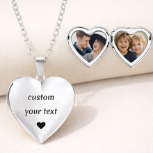 Load image into Gallery viewer, Heart-shaped silver locket with 'custom your text' engraving and a chain, with two heart compartments showing photos of a couple and children.
