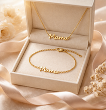 Load image into Gallery viewer, Gold 'Mama' necklace and bracelet set in an open box with flowers in the background
