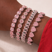 Load image into Gallery viewer, Three pink gemstone bracelets on a wrist with a red sleeve.
