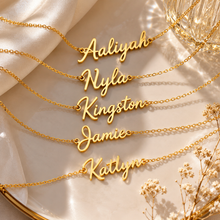 Load image into Gallery viewer, A group of name necklaces in script lettering laid out on display stand.

