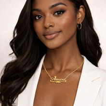 Load image into Gallery viewer, Woman wearing a gold 'Amara' necklace with heart bar and crown on the letter 'A' against a white background
