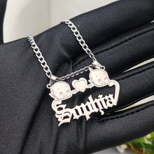 Load image into Gallery viewer, Silver necklace with Kewpie two baby faces and the name 'Sophia' on a black fabric background
