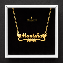 Load image into Gallery viewer, Gold necklace with double hearts design with the name 'Manisha' on a black background with HMU Ladies branding.
