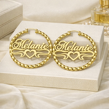 Load image into Gallery viewer, Gold hoop earrings with 'Melanie' engraving on a white box
