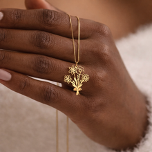 Load image into Gallery viewer, Gold necklace with a floral bouquet pendant on a hand against a neutral background
